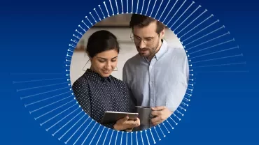 Zwei Personen betrachten ein Tablet, umgeben von einem blauen Hintergrund mit Kreismuster.