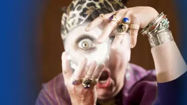 Person mit Schmuck hält magische Kugel