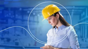 Person mit Schutzhelm in Fabrikumgebung