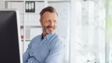 Person im Büro schaut über den Computerbildschirm.