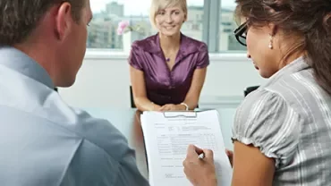 Personen in einem Büro bei einem Vorstellungsgespräch.