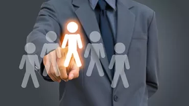 Anzugträger zeigt auf leuchtendes Symbol einer Person.