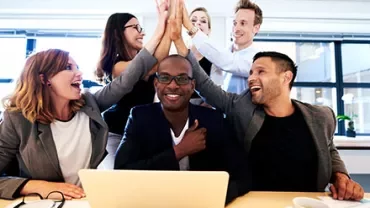 Gruppe von Menschen jubelt über Teamarbeit.