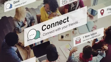 Menschen diskutieren an einem Tisch, von digitalen Nachrichten umgeben.