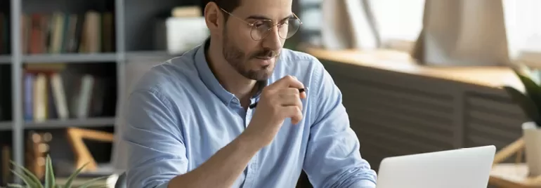 Person arbeitet am Laptop in einem modernen Büro.