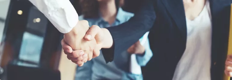 Menschen geben sich die Hand bei einem Geschäftstreffen.