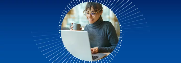 Person am Laptop mit Kaffeetasse vor einem blauen Hintergrund.