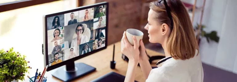 Eine Frau arbeitet im Homeoffice und hat eine Telefonkonferenz mit ihrem Team.