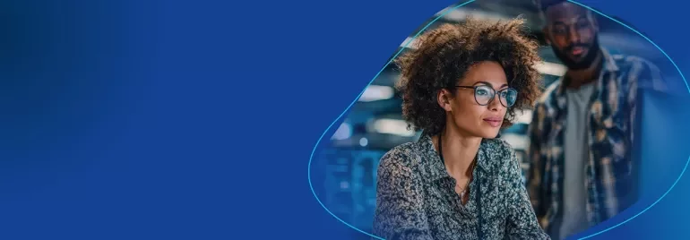 Frau arbeitet konzentriert an einem Laptop im modernen IT-Umfeld