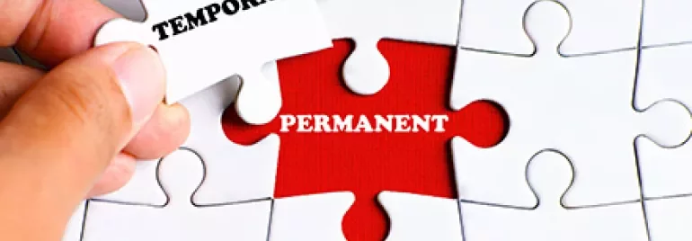 Hand fügt Puzzleteil mit 'Temporary' in 'Permanent' ein.