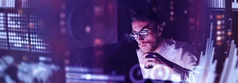 Person analysiert Daten auf Bildschirmen.