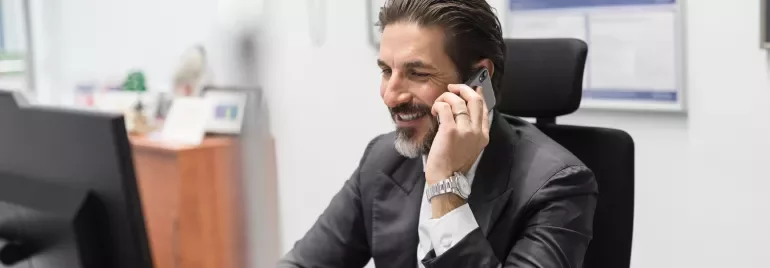 Person telefoniert im Büro und lächelt