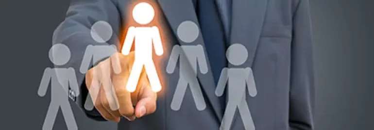 Anzugträger zeigt auf leuchtendes Symbol einer Person.
