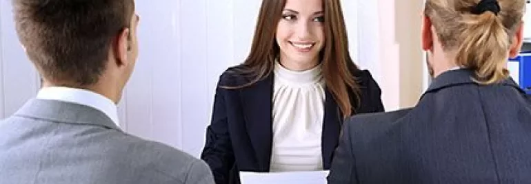 Person in Anzug bei einem Interview mit zwei anderen Personen.