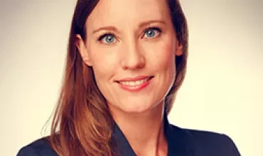 Porträt einer Person in Business-Kleidung, lächelnd