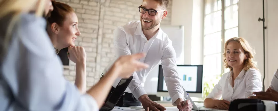 Team in einem hellen Büro bei einer Besprechung.