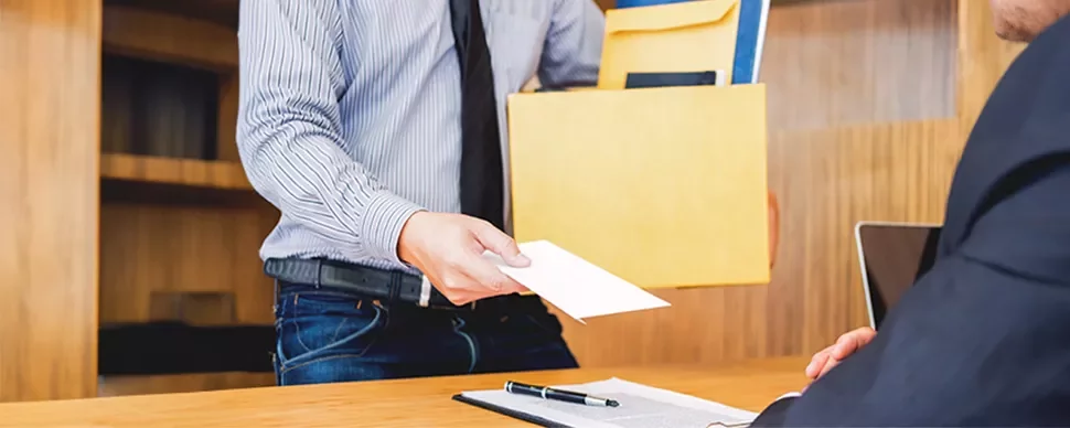 Person überreicht einen Umschlag in einem Büro.