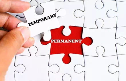 Hand fügt Puzzleteil mit 'Temporary' in 'Permanent' ein.