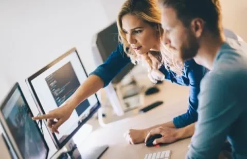Zwei Personen arbeiten gemeinsam an Computern.