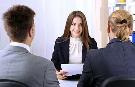 Person in Anzug bei einem Interview mit zwei anderen Personen.